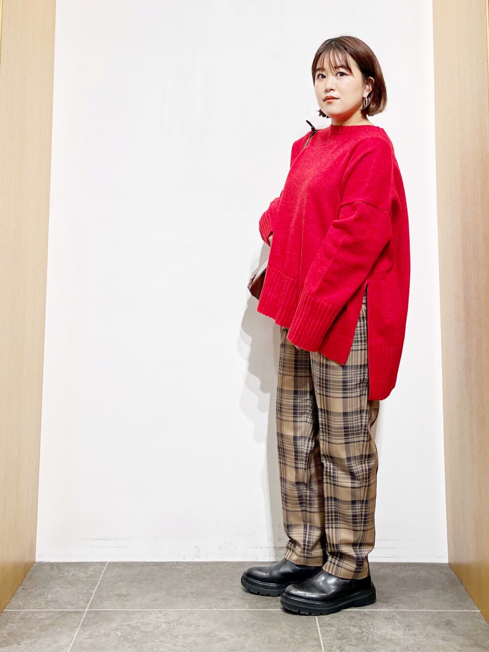 レッド系のニット/セーター、その他のその他パンツ、ブラック系のブーツを着用したレディースの冬コーディネートの2枚目の写真