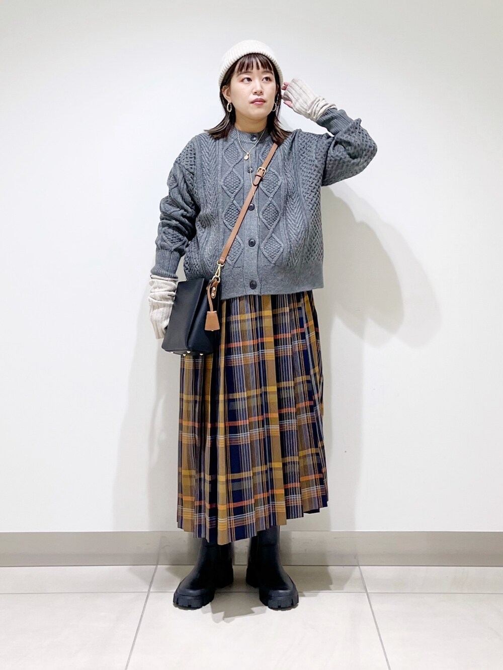 グレー系のカーディガン/ボレロ、ブルー系のスカート、ブラック系のショルダーバッグを着用したレディースの冬コーディネートの8枚目の写真