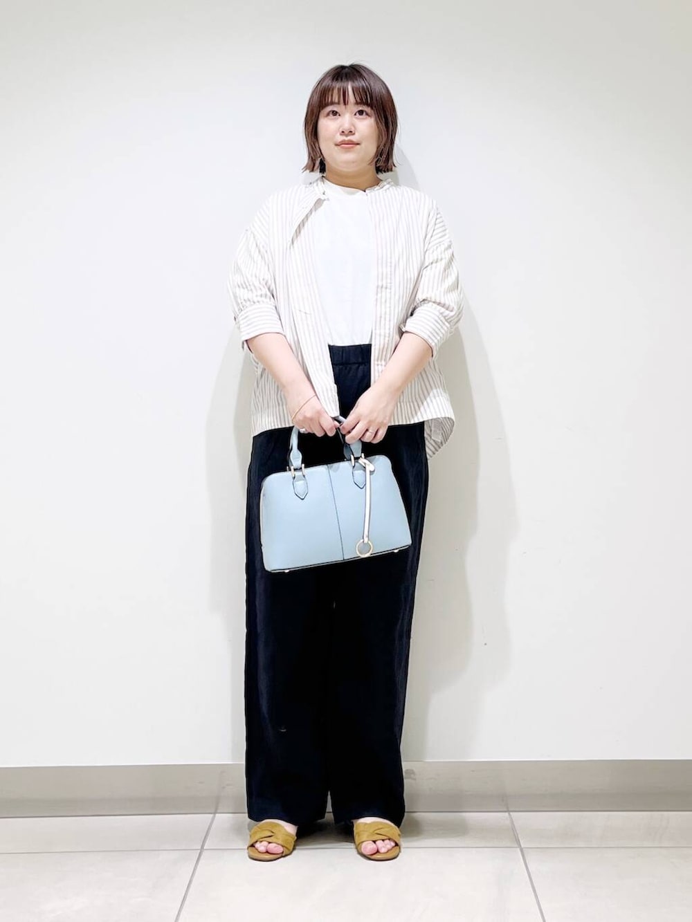 ブラック系のその他パンツ、ベージュ系のシャツ/ブラウス、イエロー系のサンダルを着用したレディースの春コーディネートの10枚目の写真