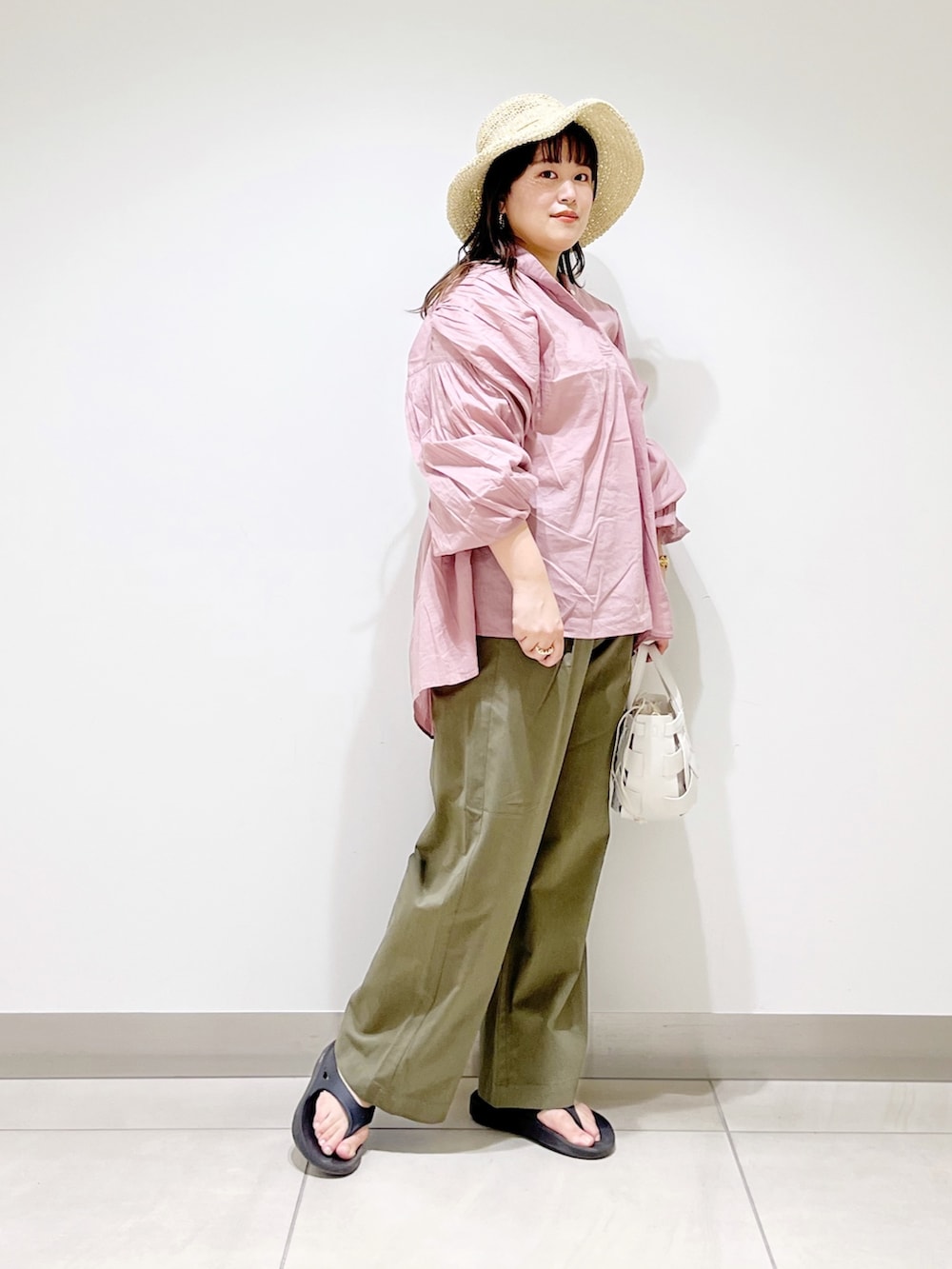 ピンク系のシャツ/ブラウス、グリーン系のその他パンツ、ホワイト系のショルダーバッグを着用したレディースの春コーディネートの4枚目の写真