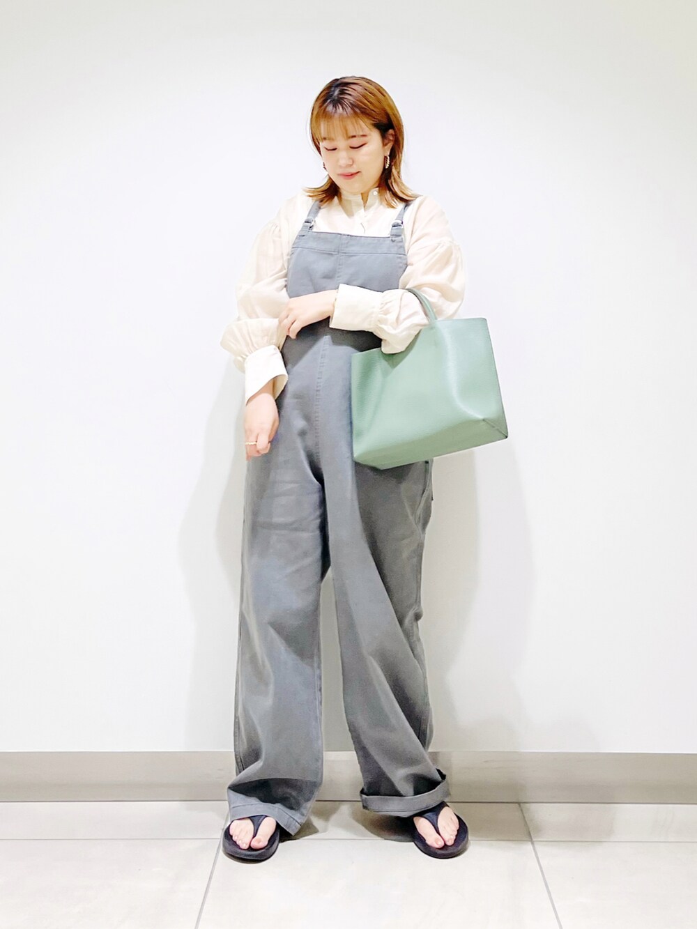 グレー系のサロペット/オーバーオール、グリーン系のトートバッグ、ブラック系のサンダルを着用したレディースの夏コーディネートの2枚目の写真