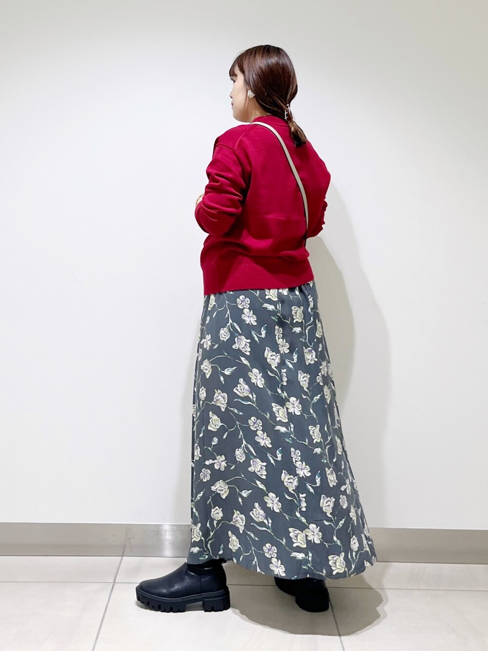 レッド系のトップス、グレー系のスカート、グレー系のショルダーバッグを着用したレディースの秋コーディネートの4枚目の写真