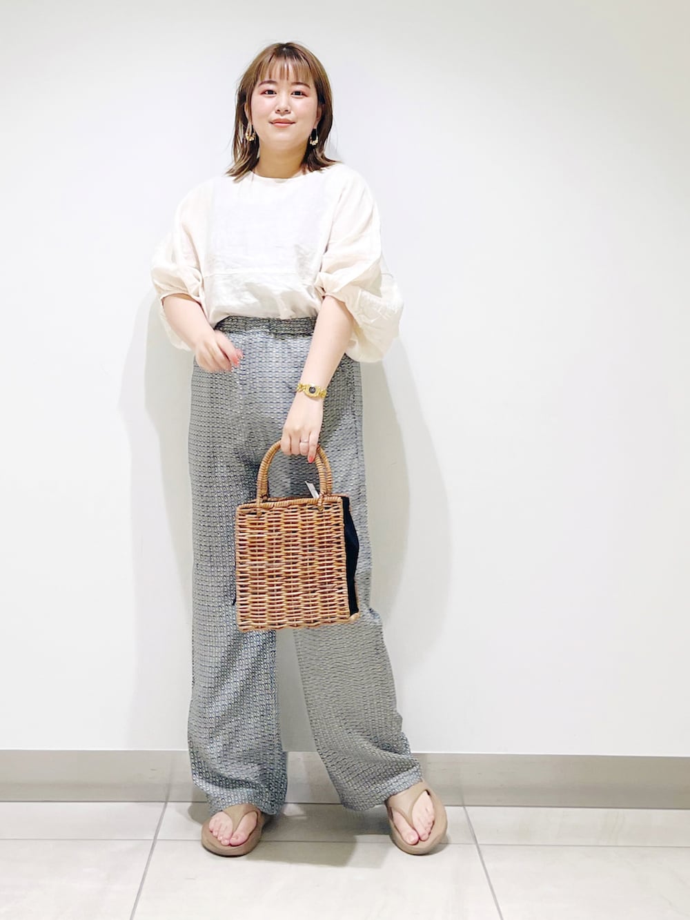 ブラック系のハンドバッグ、グリーン系のその他パンツ、ベージュ系のシャツ/ブラウスを着用したレディースの夏コーディネートの4枚目の写真