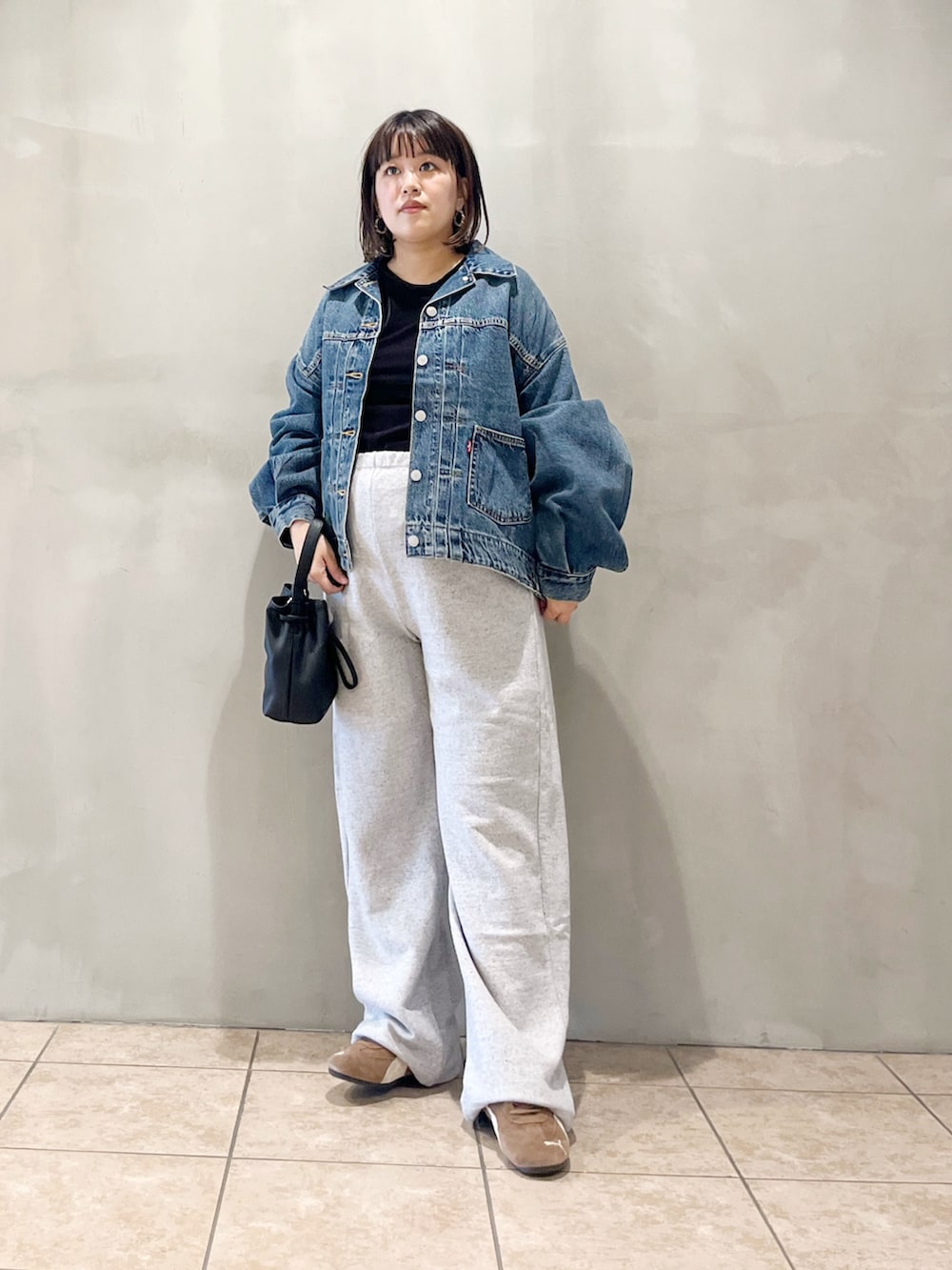 ブルー系のデニムジャケット、ブラック系のスニーカー、グレー系のその他パンツを着用したレディースの秋コーディネートの2枚目の写真