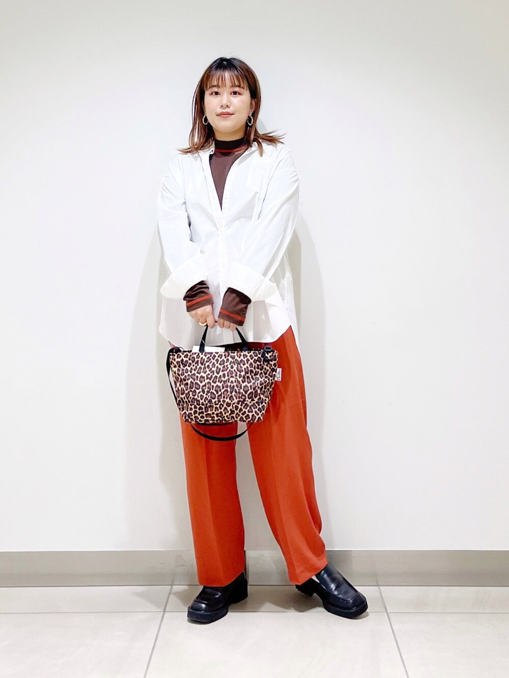 ホワイト系のシャツ/ブラウス、オレンジ系のその他パンツ、その他のショルダーバッグを着用したレディースの秋コーディネートの4枚目の写真