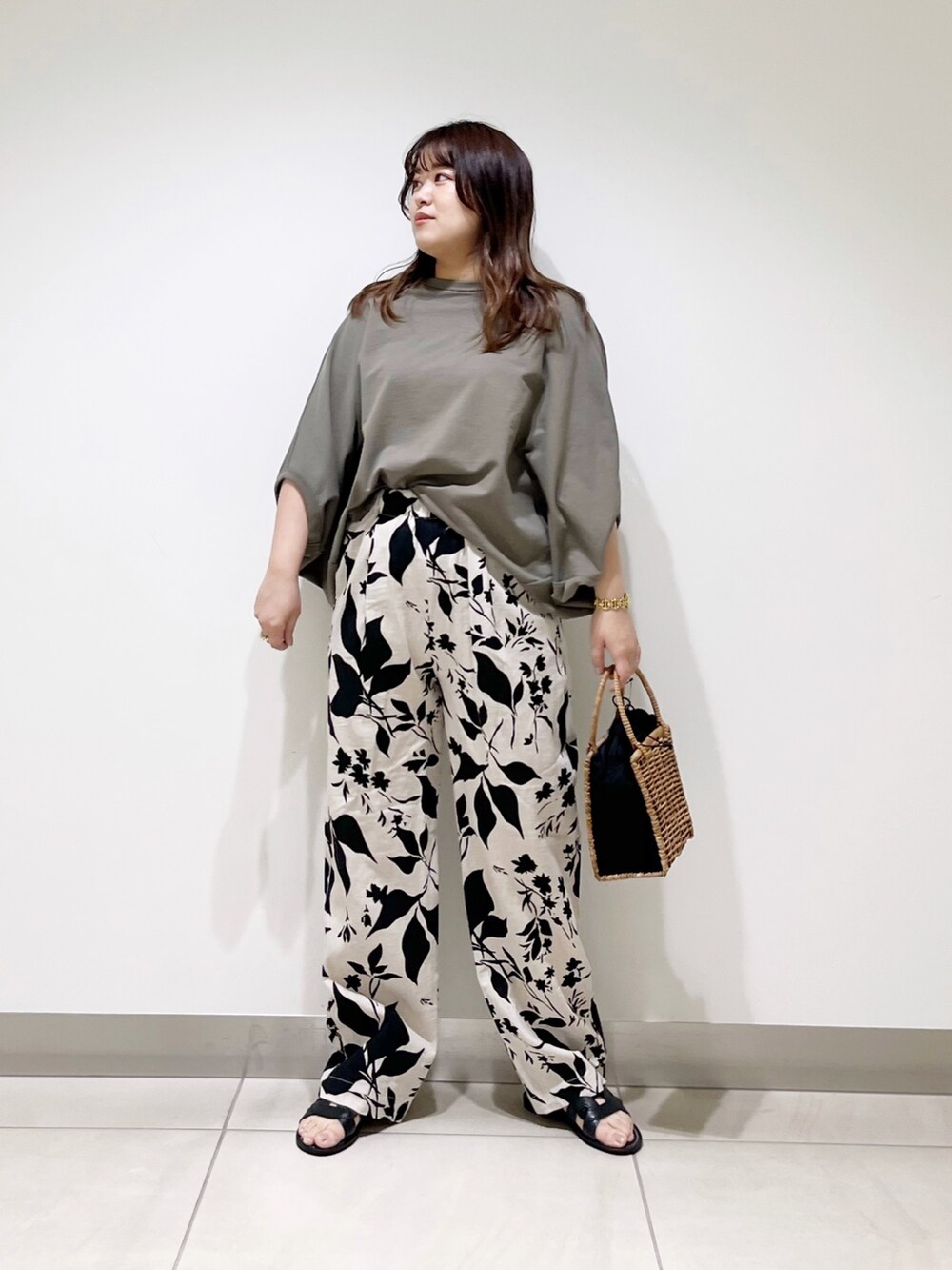 グリーン系のTシャツ/カットソー、ベージュ系のその他パンツ、ブラック系のハンドバッグを着用したレディースの春コーディネートの3枚目の写真