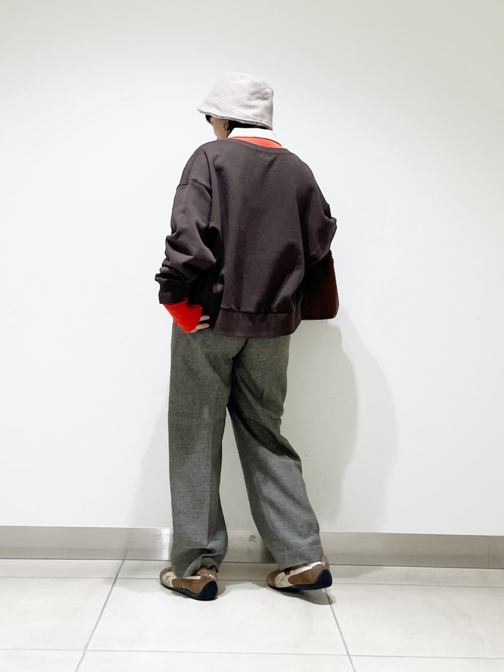 レッド系のニット/セーター、グレー系のその他パンツ、ブラック系のスニーカーを着用したレディースの秋コーディネートの7枚目の写真