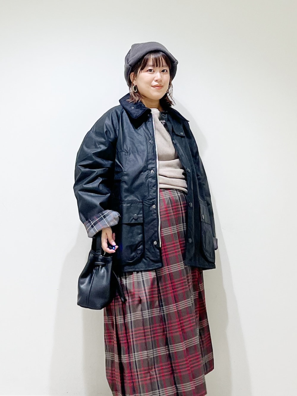 ブラック系のテーラードジャケット、グレー系のTシャツ/カットソー、ブラウン系のスカートを着用したレディースの秋コーディネートの4枚目の写真