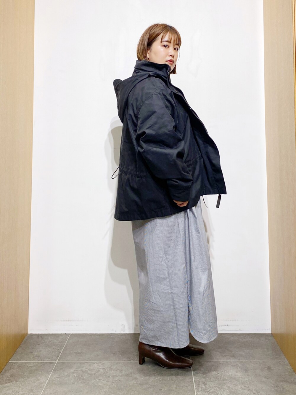 ブラック系のその他アウター、ホワイト系のワンピース、ブラウン系のブーツを着用したレディースの秋コーディネートの4枚目の写真