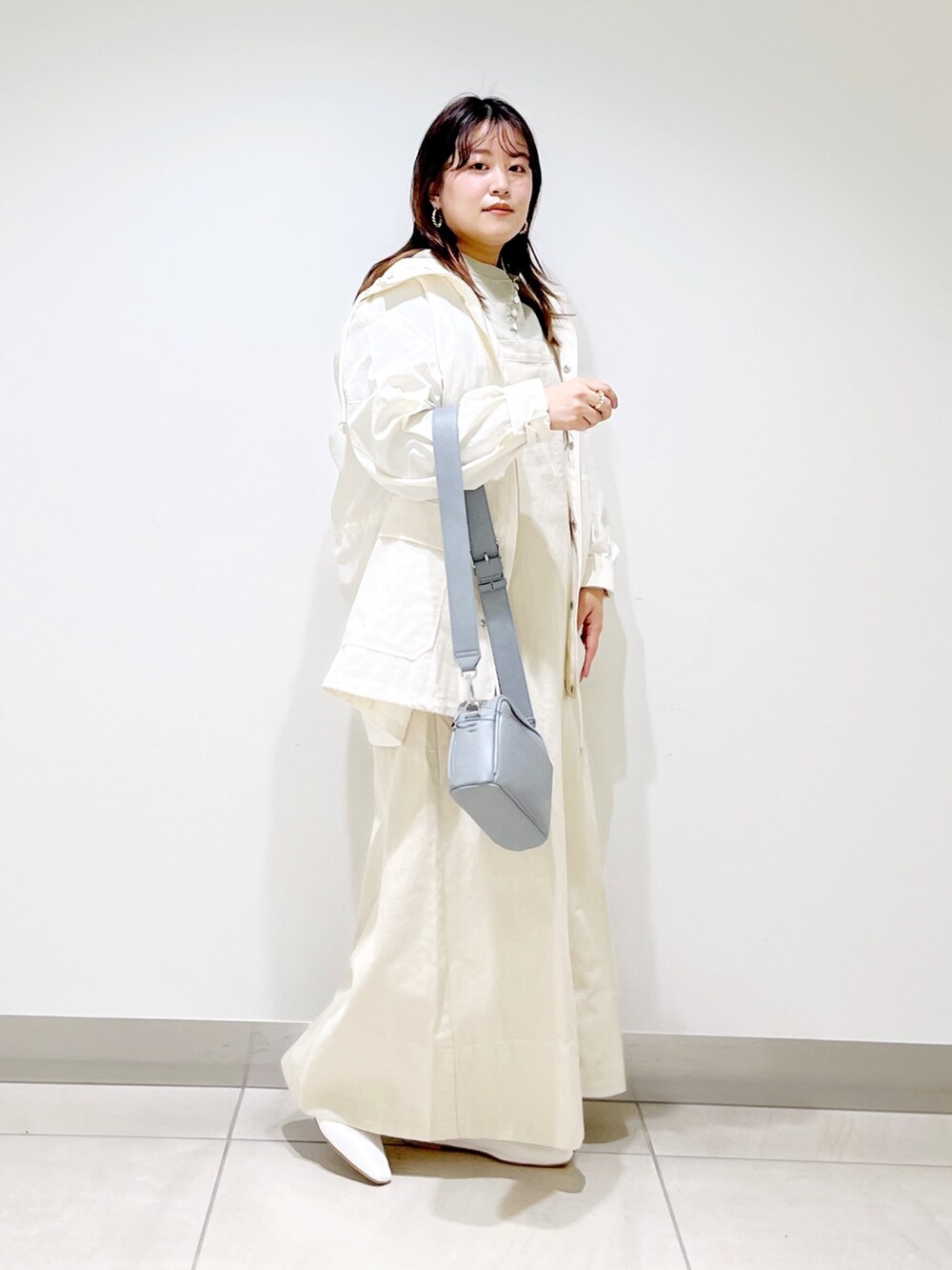 ベージュ系のワンピース、ホワイト系のブルゾン、グリーン系のTシャツ/カットソーを着用したレディースの春コーディネートの6枚目の写真