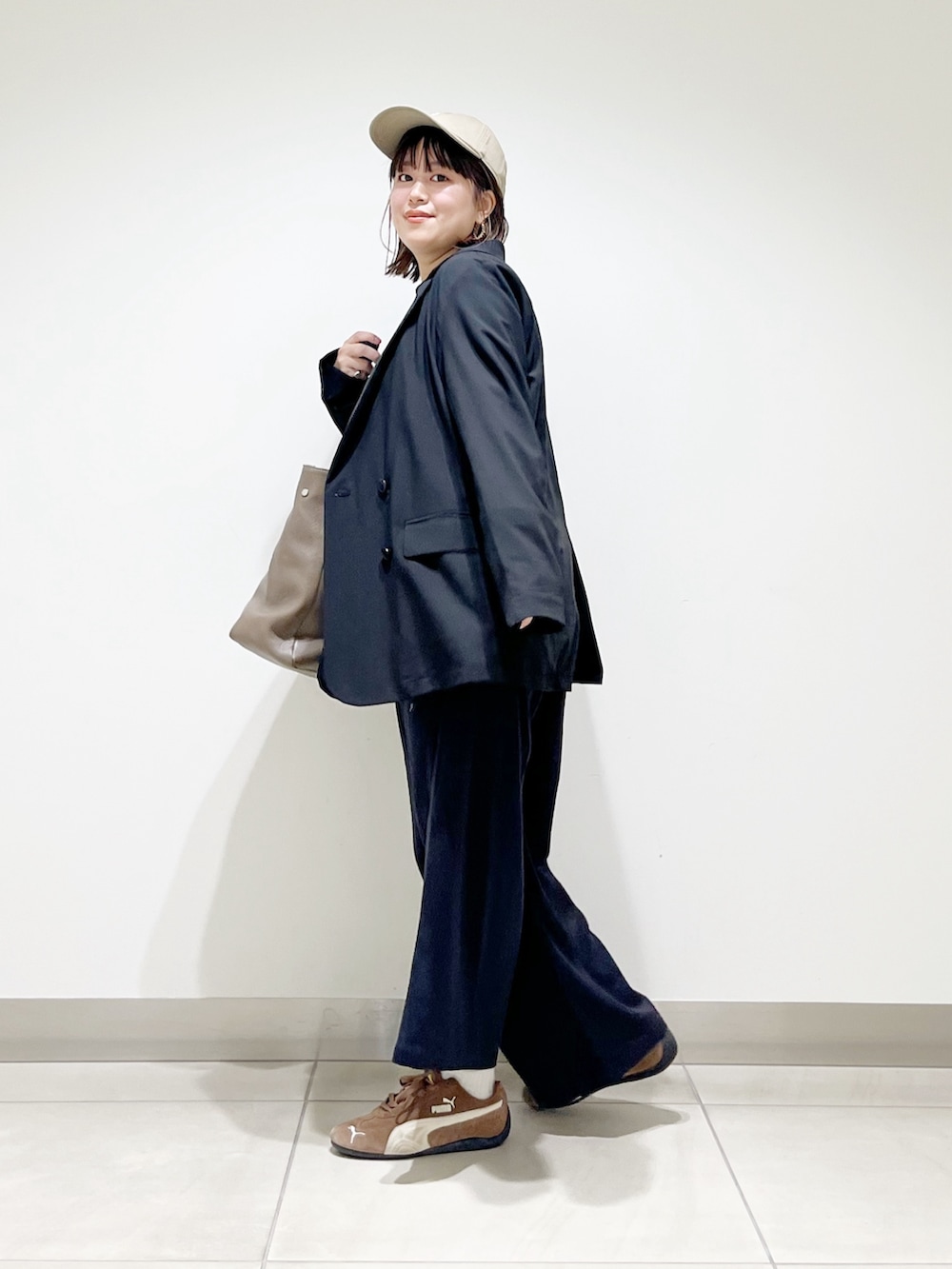 ブラック系のその他アウター、グレー系のニット/セーター、グレー系のトートバッグを着用したレディースの秋コーディネートの4枚目の写真