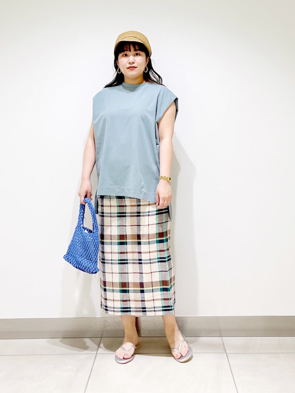 ブルー系のTシャツ/カットソー、グリーン系のスカート、ブルー系のハンドバッグを着用したレディースの夏コーディネートの2枚目の写真