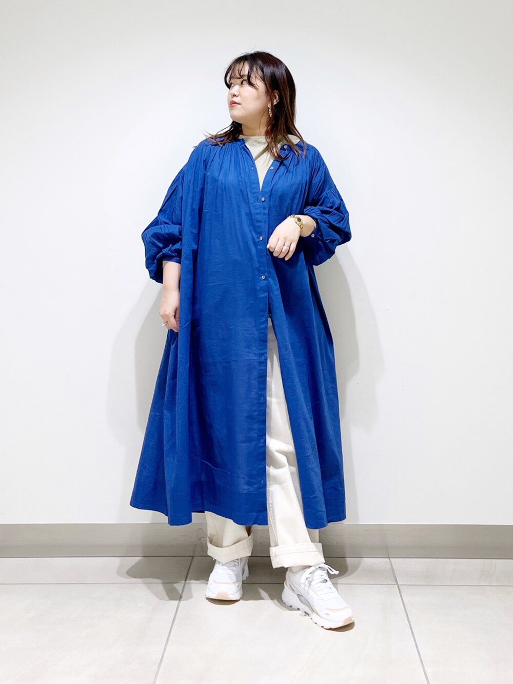 ブルー系のワンピース、ベージュ系のデニムパンツ、ベージュ系のTシャツ/カットソーを着用したレディースの春コーディネートの2枚目の写真