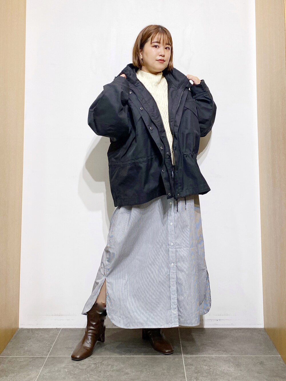 ブラック系のその他アウター、ホワイト系のワンピース、ブラウン系のブーツを着用したレディースの秋コーディネートの5枚目の写真