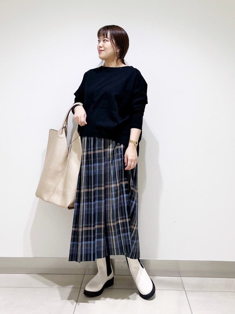 ブラック系のTシャツ/カットソー、ゴールド系のトートバッグ、ホワイト系のブーツを着用したレディースの秋コーディネートの2枚目の写真