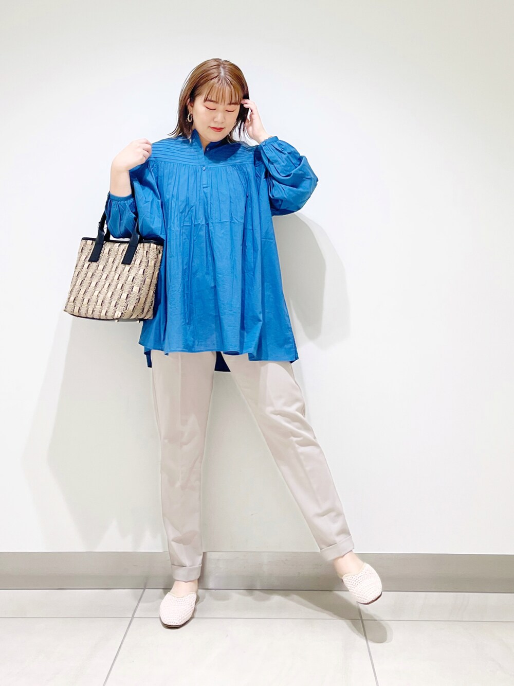 ブルー系のシャツ/ブラウス、ブラック系のショルダーバッグ、ベージュ系のその他パンツを着用したレディースの春コーディネートの2枚目の写真