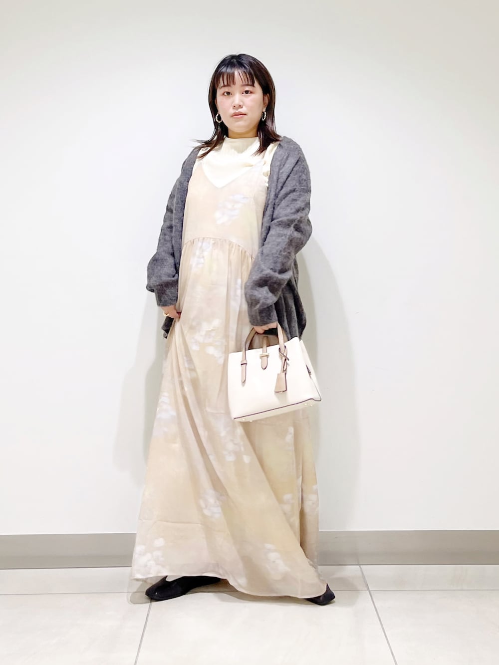 ベージュ系のワンピース、ホワイト系のトートバッグ、ホワイト系のニット/セーターを着用したレディースの秋コーディネートの2枚目の写真