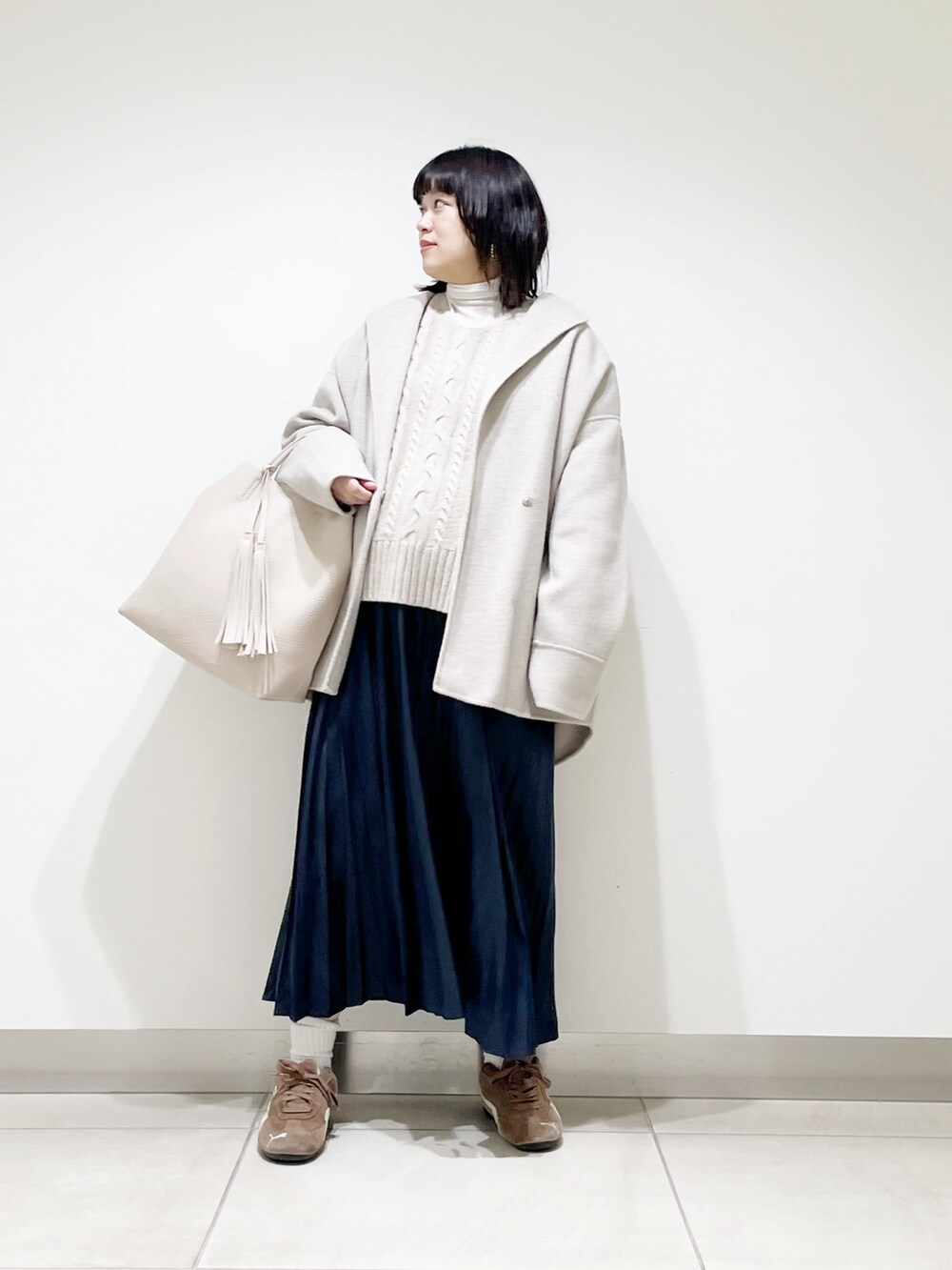 ベージュ系のその他アウター、ベージュ系のニット/セーター、ホワイト系のトートバッグを着用したレディースの秋コーディネートの2枚目の写真
