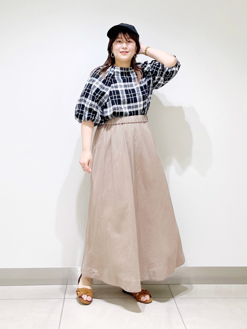 ベージュ系のスカート、ベージュ系のサンダル、ブラック系のシャツ/ブラウスを着用したレディースの夏コーディネートの10枚目の写真