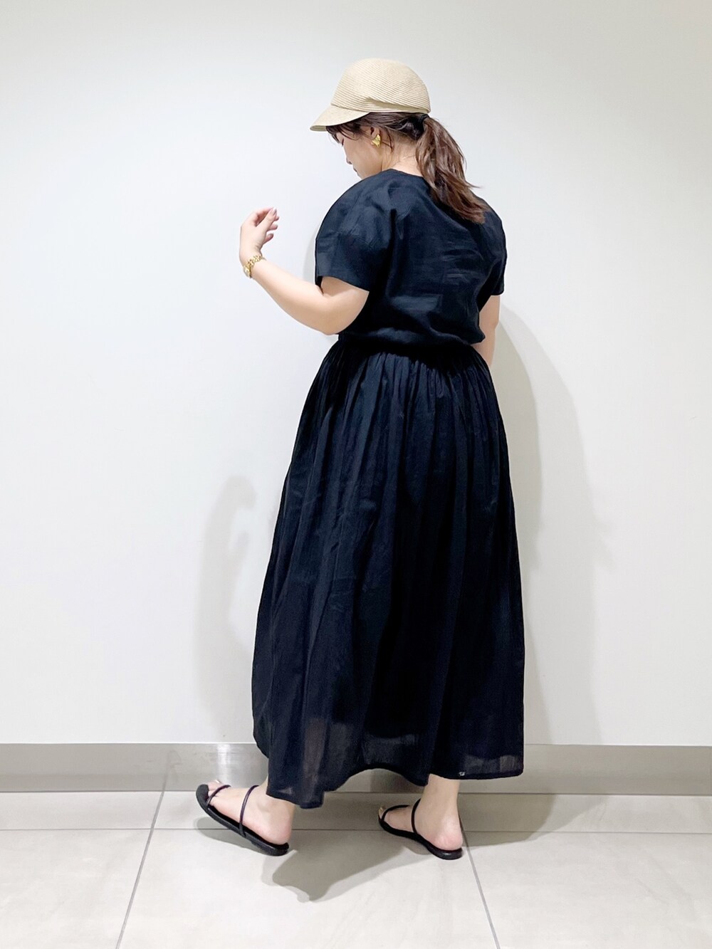 ブラック系のワンピース、ブラック系のサンダル、ベージュ系のキャスケットを着用したレディースの夏コーディネートの9枚目の写真