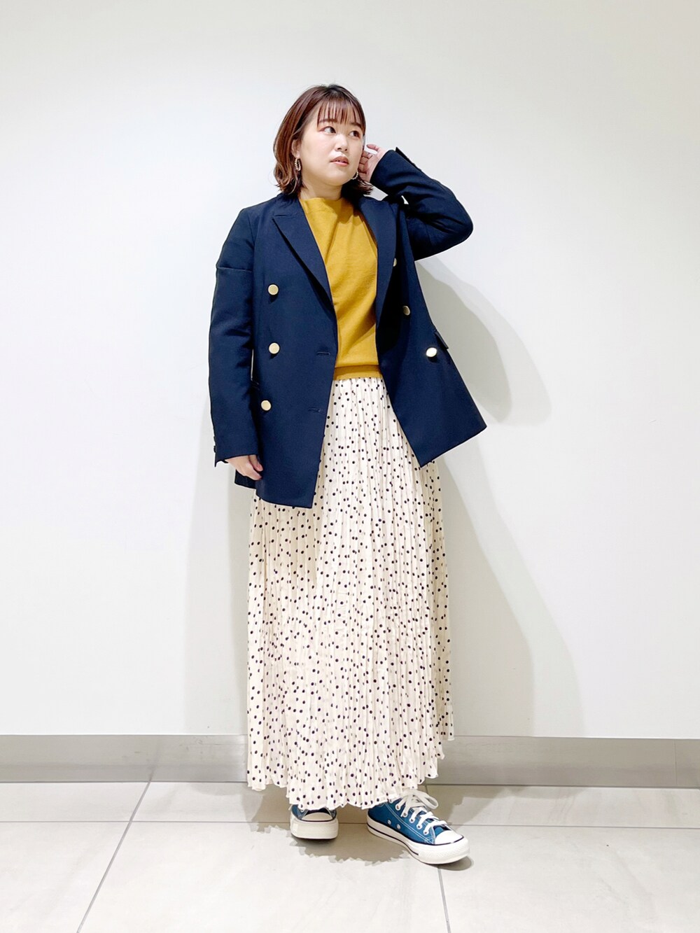 ブルー系のその他アウター、イエロー系のニット/セーター、ホワイト系のスカートを着用したレディースの冬コーディネートの4枚目の写真