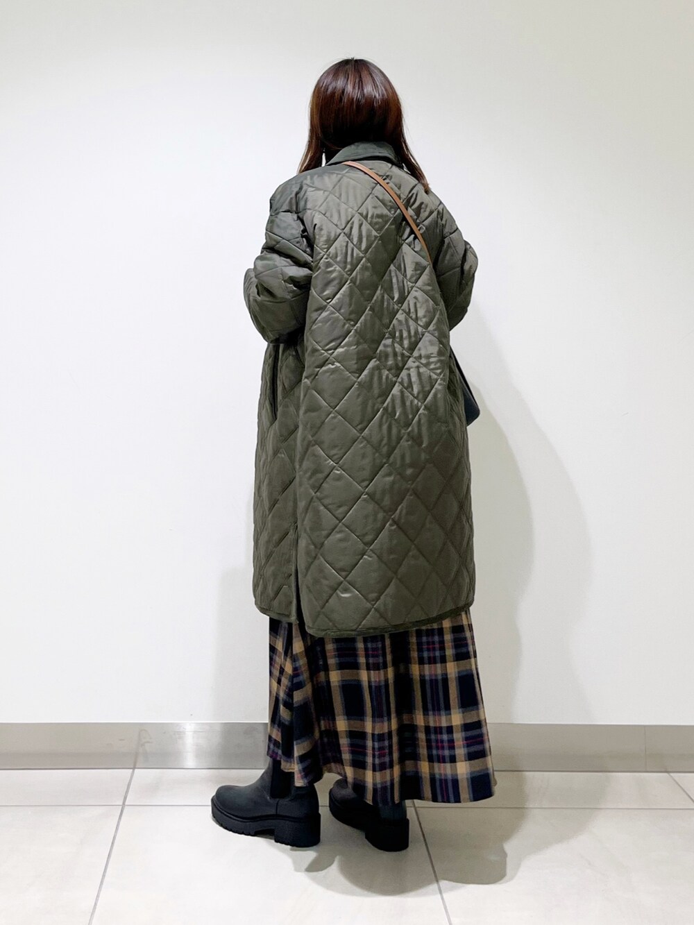 グリーン系のダウンジャケット/コート、ホワイト系のトップス、ブラウン系のスカートを着用したレディースの秋コーディネートの9枚目の写真