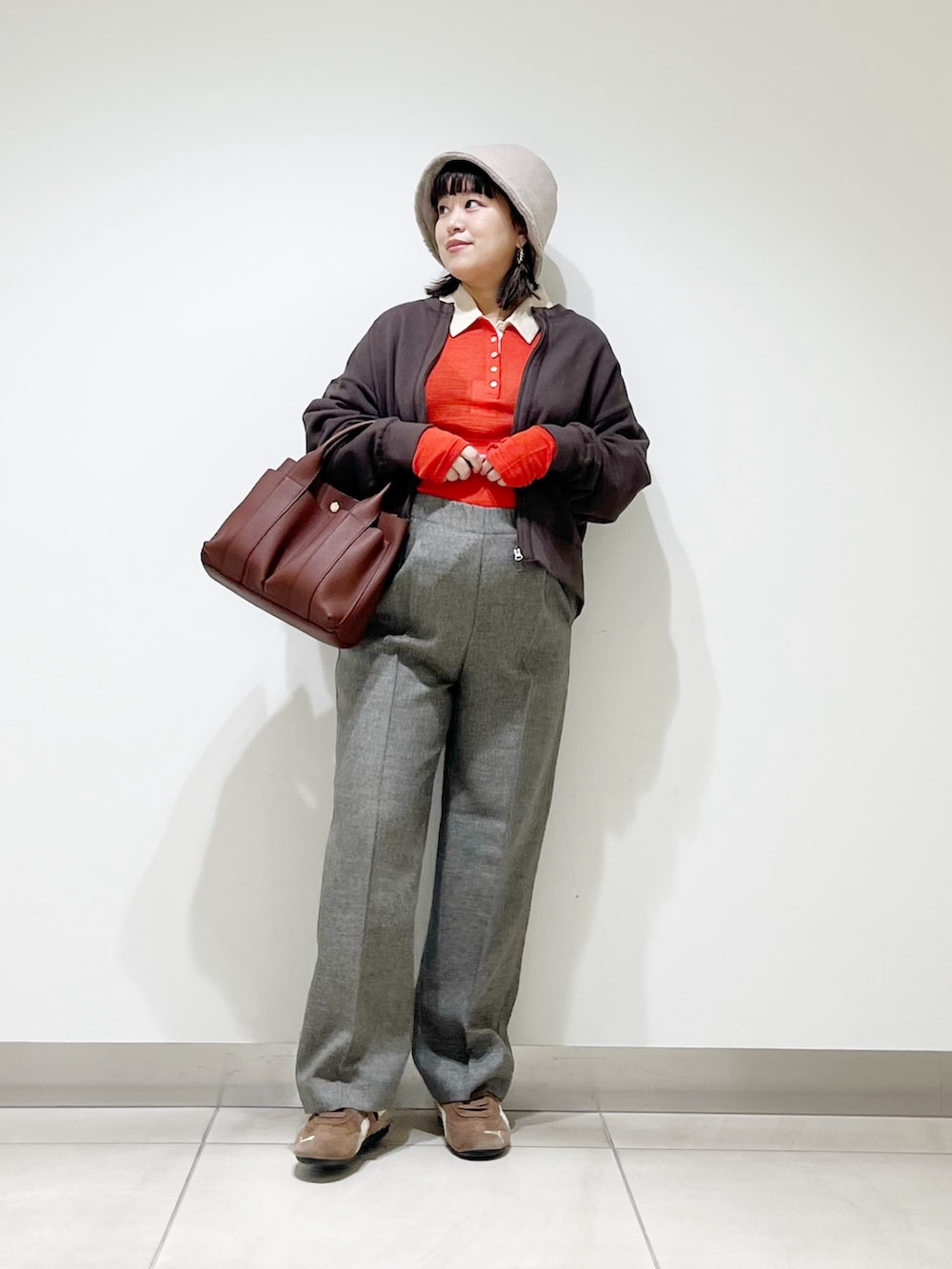 レッド系のニット/セーター、グレー系のその他パンツ、ブラック系のスニーカーを着用したレディースの秋コーディネートの8枚目の写真