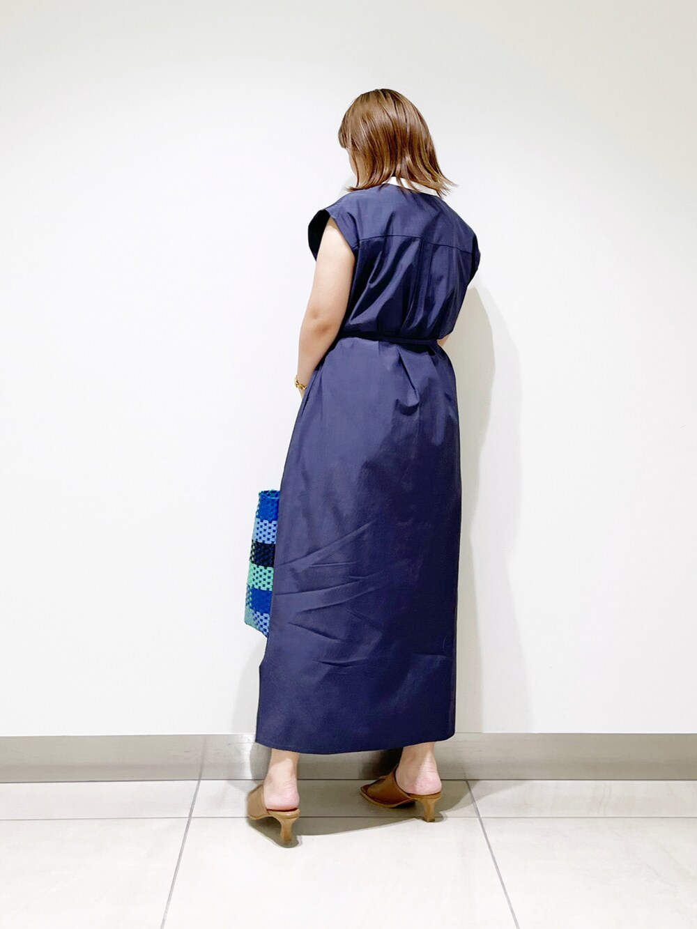 ブルー系のワンピース、ブルー系のトートバッグ、ベージュ系のサンダルを着用したレディースの夏コーディネートの3枚目の写真
