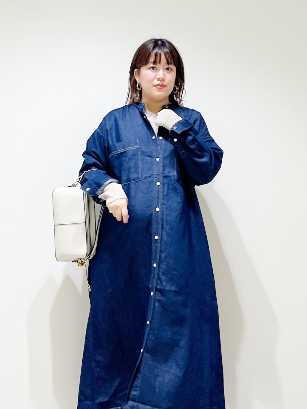 ブルー系のワンピース、ベージュ系のニット/セーター、ホワイト系のショルダーバッグを着用したレディースの秋コーディネートの7枚目の写真