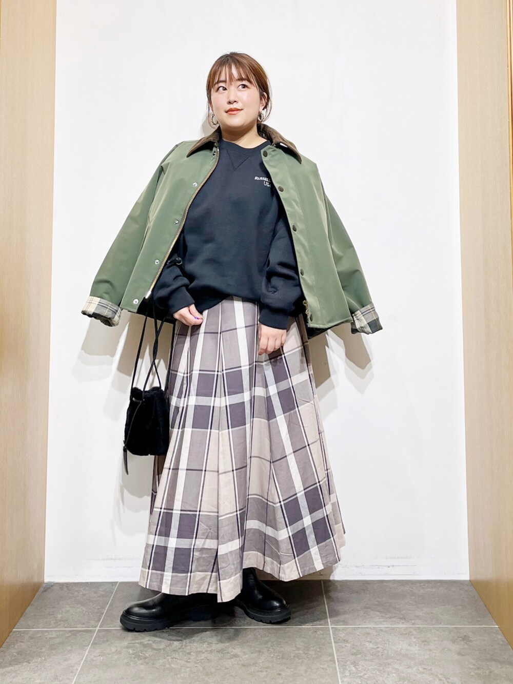 グリーン系のその他アウター、ブラック系のスウェット、ブラック系のハンドバッグを着用したレディースの冬コーディネートの5枚目の写真