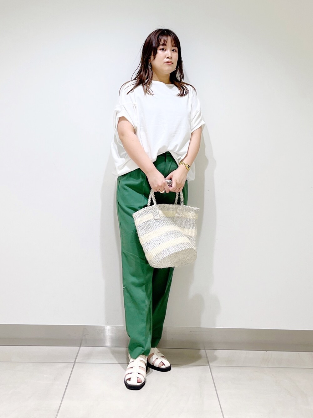 グリーン系のその他パンツ、ホワイト系のTシャツ/カットソー、ホワイト系のハンドバッグを着用したレディースの春コーディネートの3枚目の写真