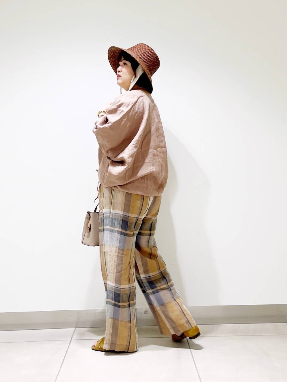 ベージュ系のハンドバッグ、イエロー系のその他パンツ、イエロー系のサンダルを着用したレディースの春コーディネートの5枚目の写真