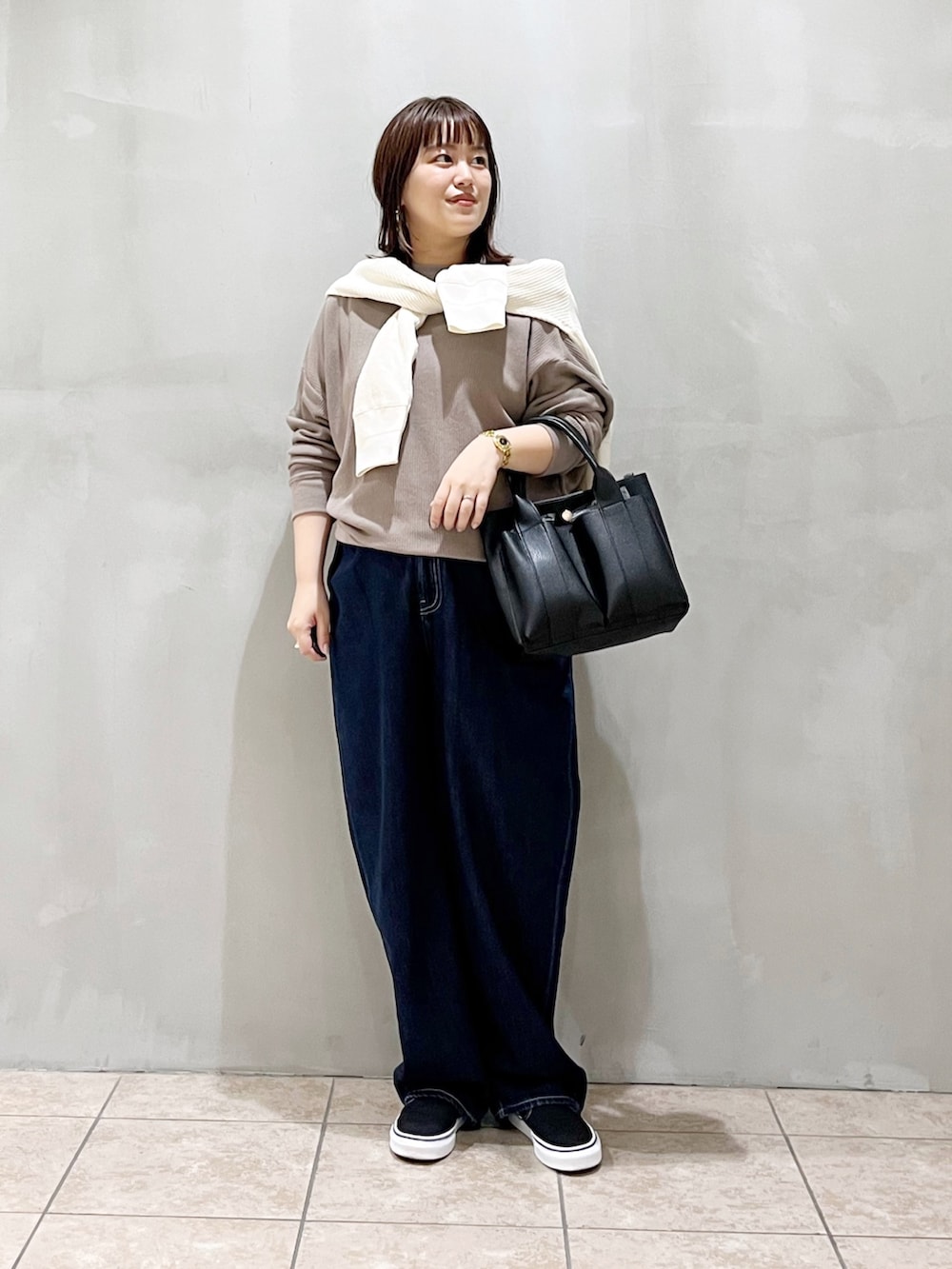 グレー系のTシャツ/カットソー、ホワイト系のカーディガン/ボレロ、ブラック系のトートバッグを着用したレディースの秋コーディネートの4枚目の写真