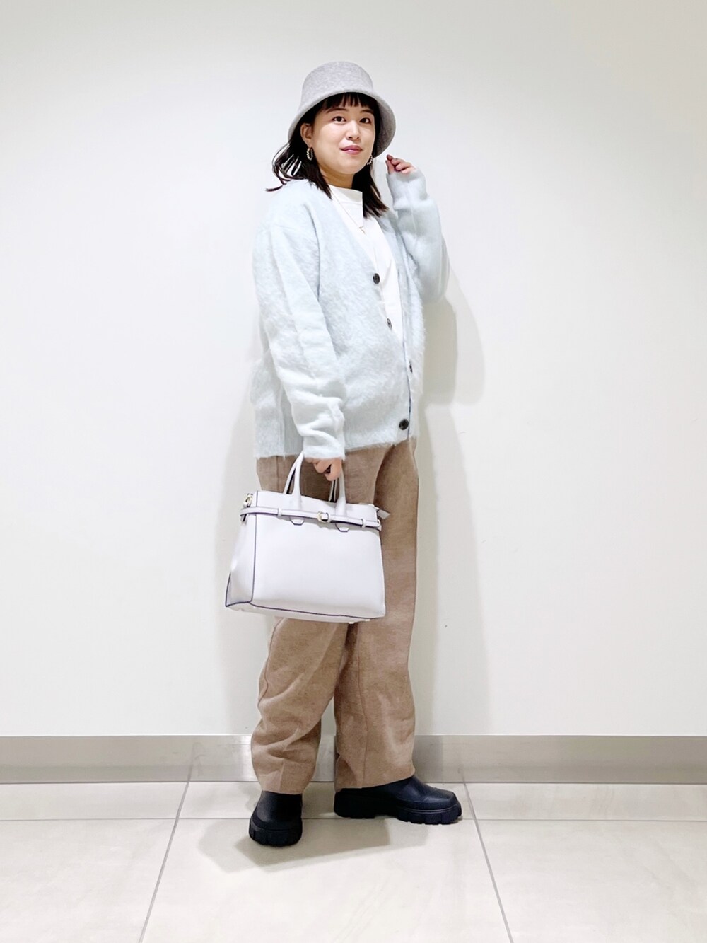 グリーン系のカーディガン/ボレロ、ベージュ系のその他パンツ、ブラック系のブーツを着用したレディースの秋コーディネートの10枚目の写真