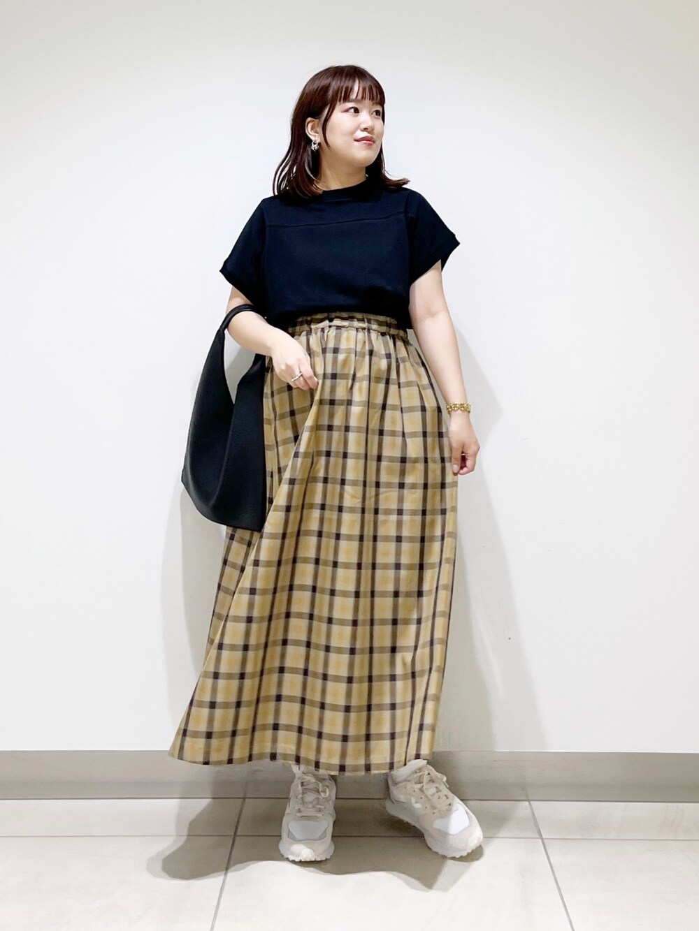 ホワイト系のスニーカー、ブラック系のTシャツ/カットソー、ブラック系のトートバッグを着用したレディースの秋コーディネートの9枚目の写真