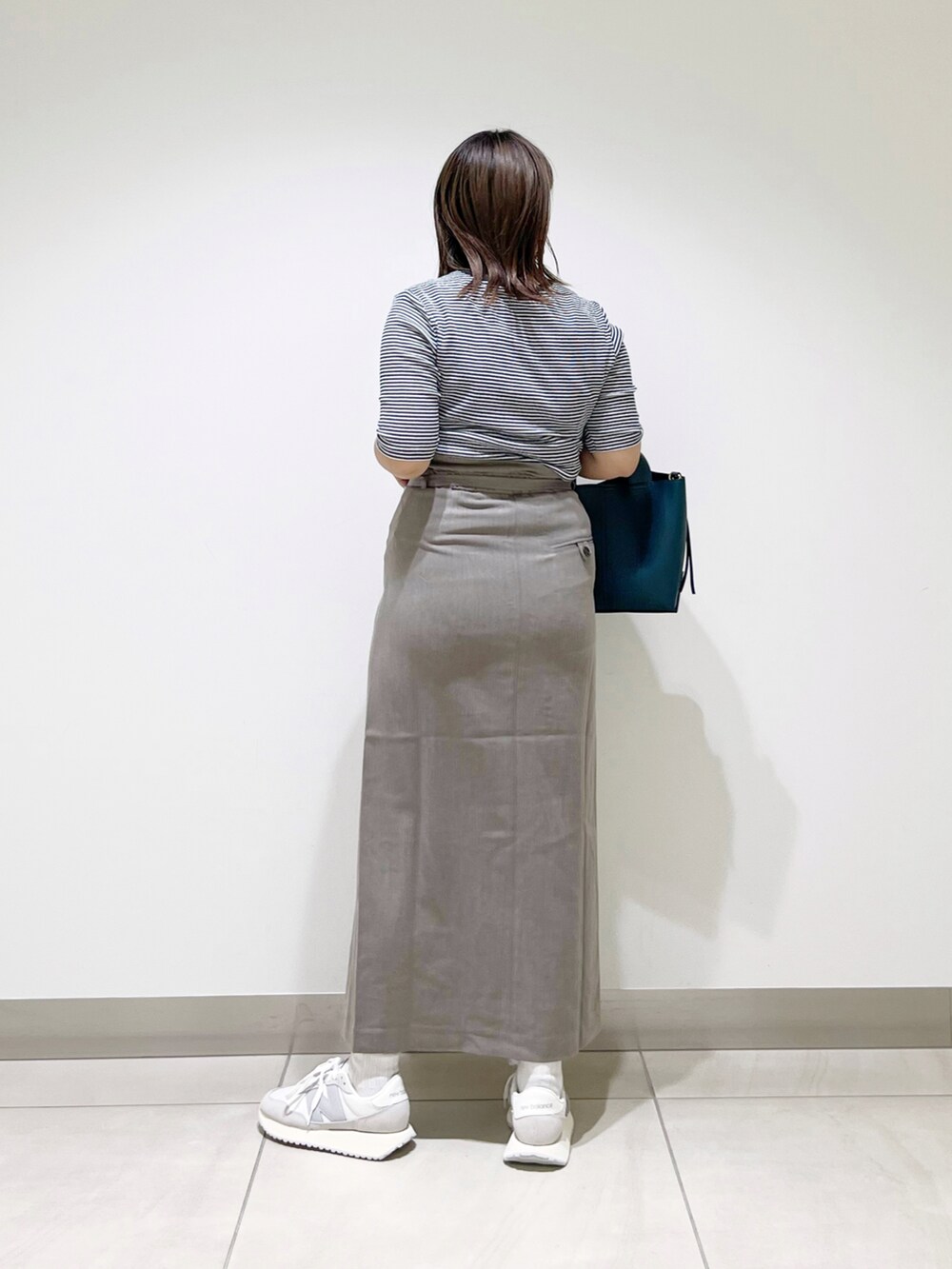 ブラウン系のスカート、ブルー系のトートバッグ、ホワイト系のスニーカーを着用したレディースの夏コーディネートの4枚目の写真