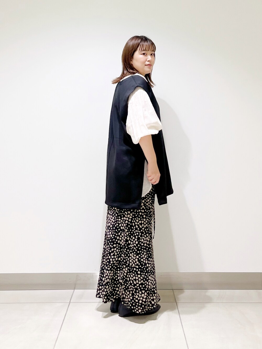 ブラック系のベスト、ホワイト系のシャツ/ブラウス、ブラック系のスカートを着用したレディースの夏コーディネートの5枚目の写真