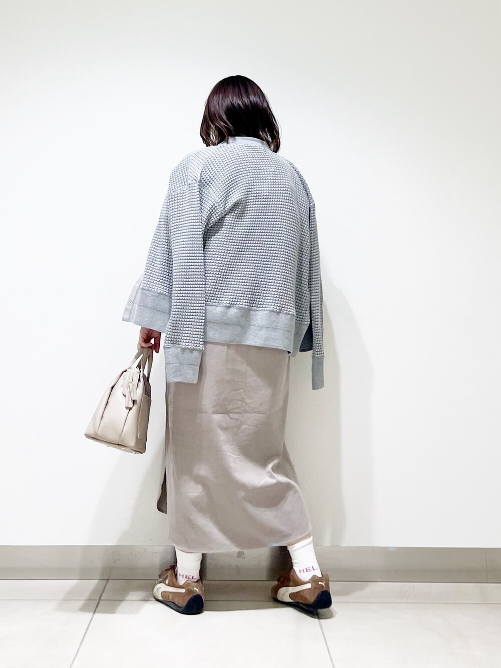 ベージュ系のワンピース、グレー系のカーディガン/ボレロ、グレー系のボストンバッグを着用したレディースの秋コーディネートの4枚目の写真