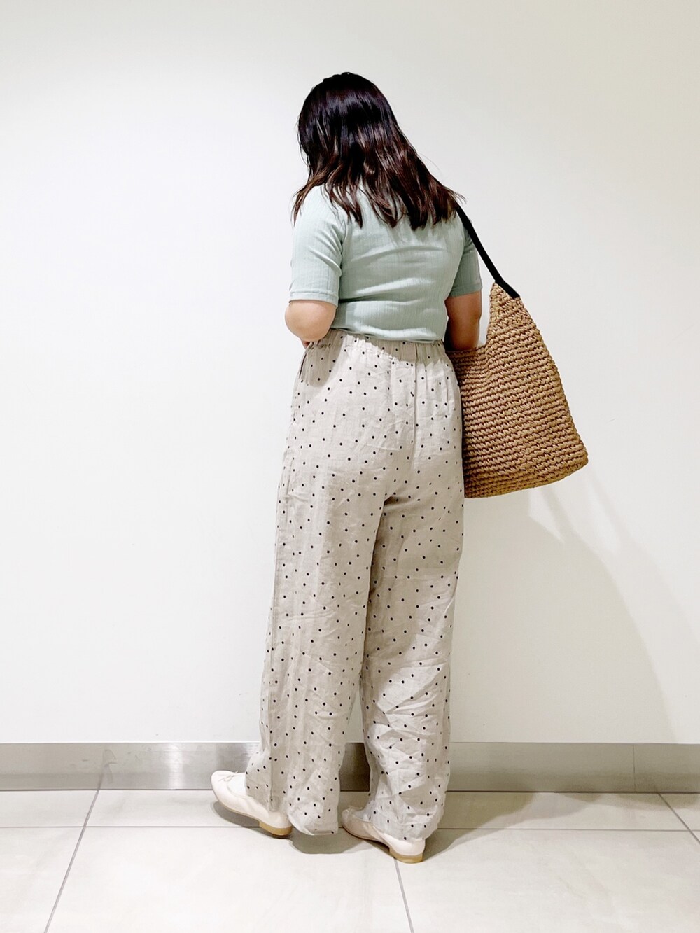 グリーン系のTシャツ/カットソー、ベージュ系のその他パンツ、ブラウン系のバッグを着用したレディースの春コーディネートの4枚目の写真