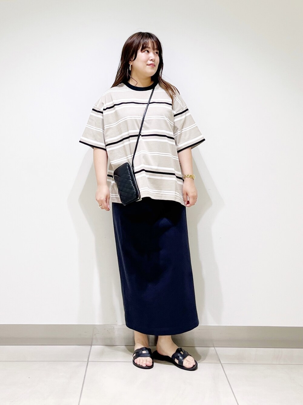 ベージュ系のTシャツ/カットソー、ブルー系のスカート、ブラック系のショルダーバッグを着用したレディースの夏コーディネートの7枚目の写真