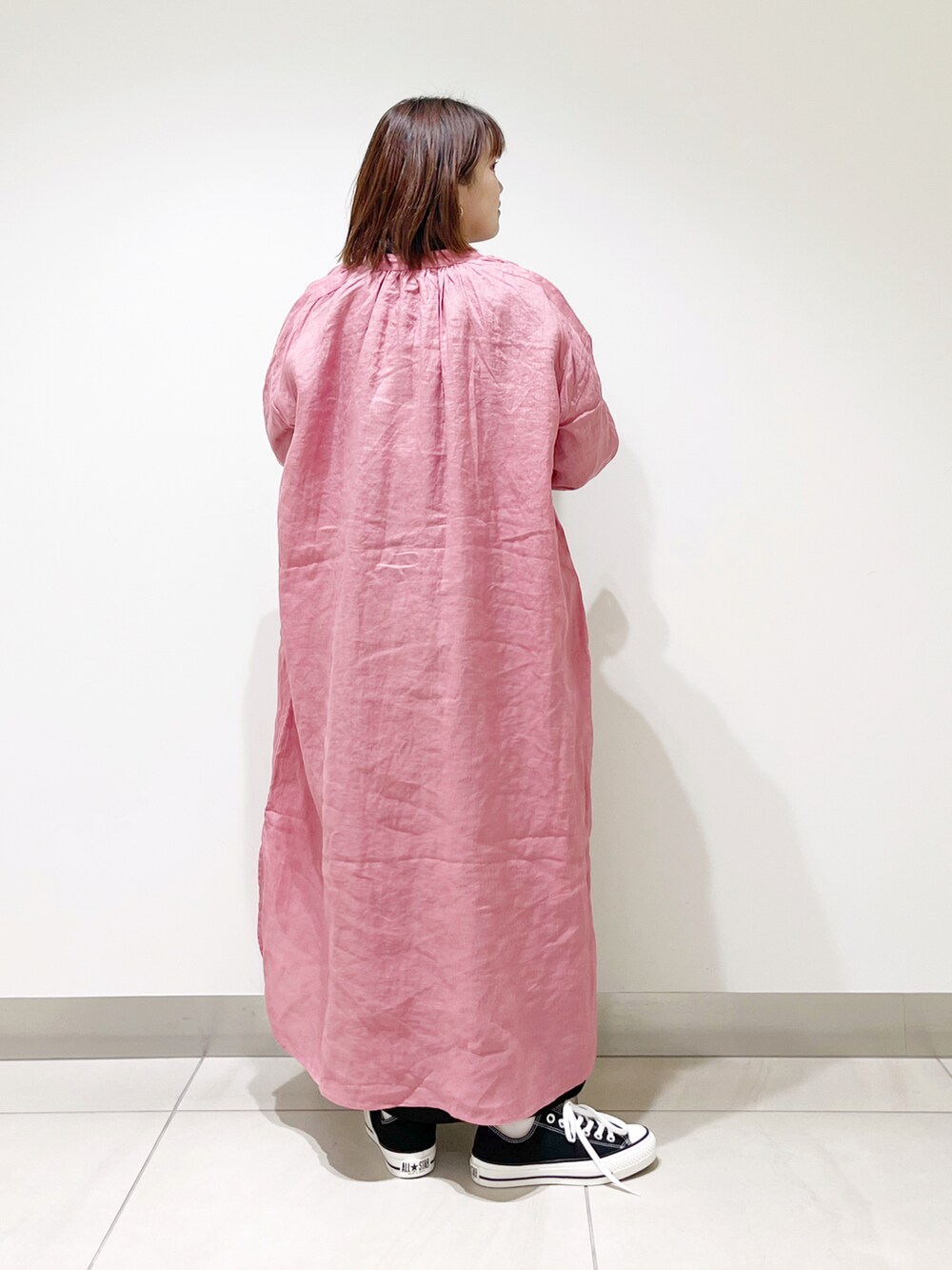 ブラック系のワンピース、ピンク系のワンピース、ブラック系のスニーカーを着用したレディースの春コーディネートの3枚目の写真