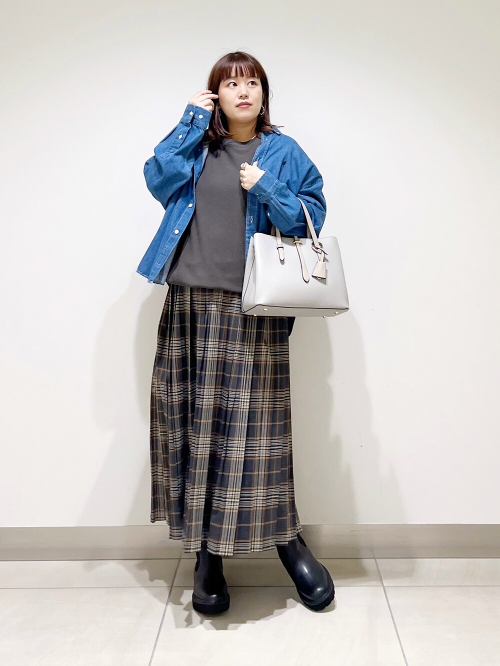 グレー系のTシャツ/カットソー、グレー系のトートバッグ、グレー系のスカートを着用したレディースの秋コーディネートの4枚目の写真