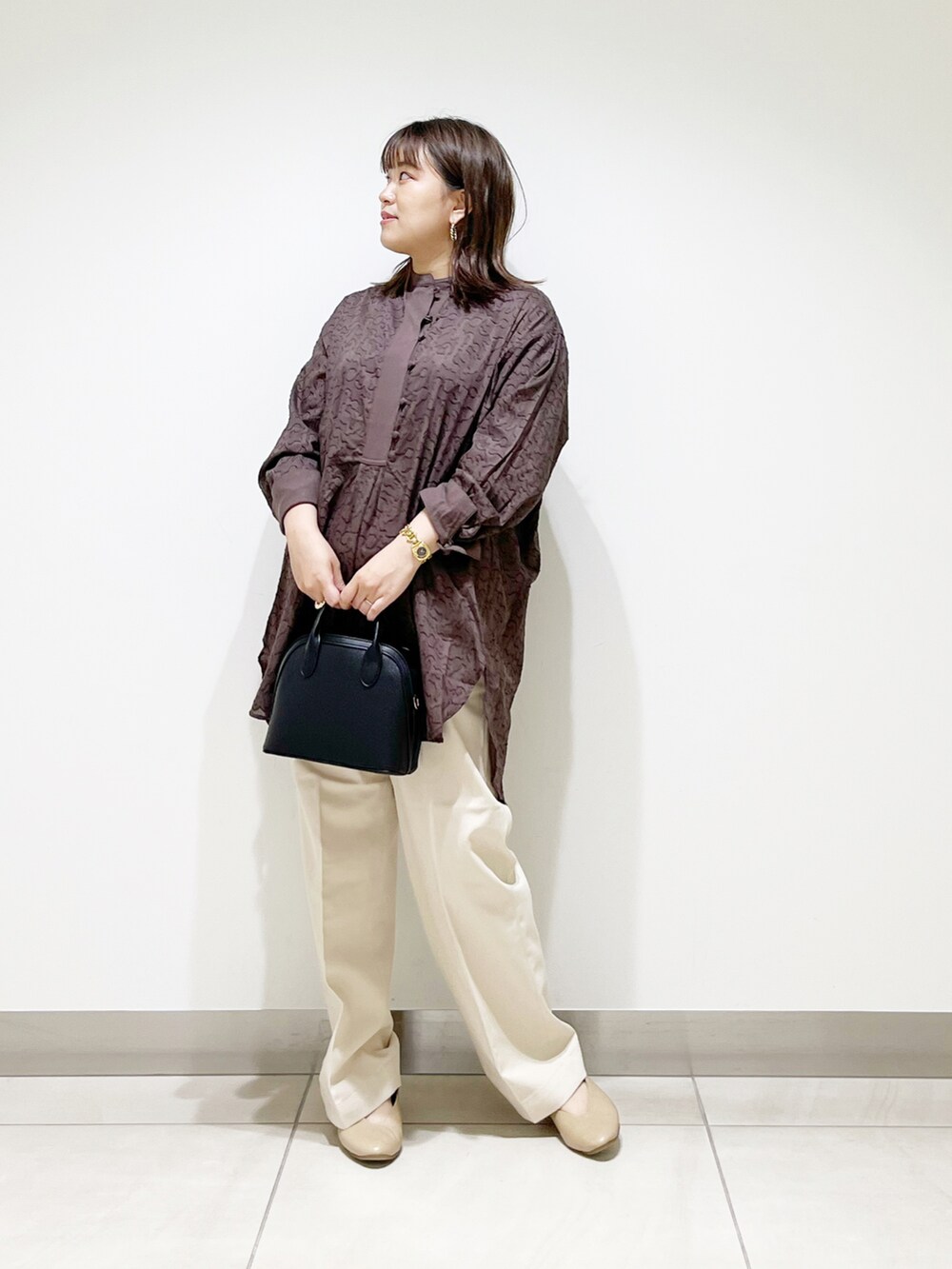 ブラウン系のシャツ/ブラウス、ブラック系のショルダーバッグ、ベージュ系のその他パンツを着用したレディースの秋コーディネートの2枚目の写真
