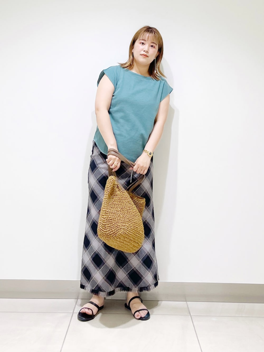 グリーン系のTシャツ/カットソー、ブラック系のスカート、ベージュ系のトートバッグを着用したレディースの夏コーディネートの5枚目の写真
