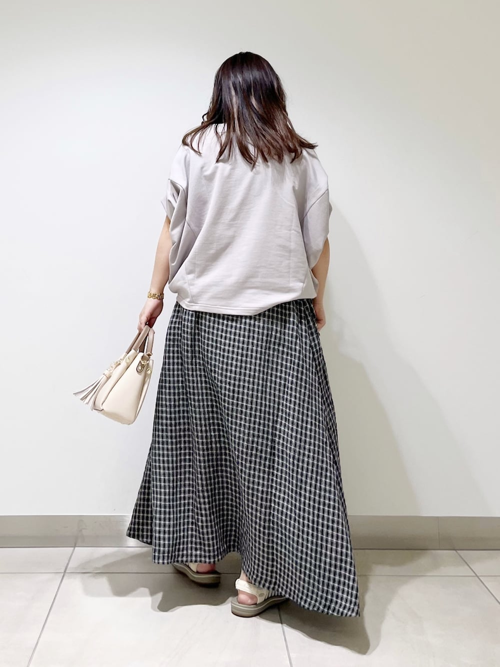 グレー系のTシャツ/カットソー、その他のスカート、ホワイト系のトートバッグを着用したレディースの春コーディネートの5枚目の写真