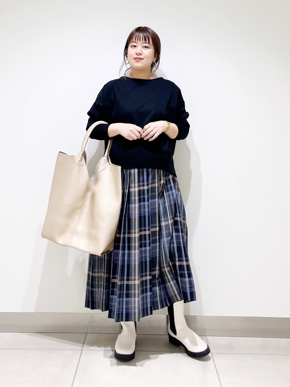 ブラック系のTシャツ/カットソー、ゴールド系のトートバッグ、ホワイト系のブーツを着用したレディースの秋コーディネートの7枚目の写真