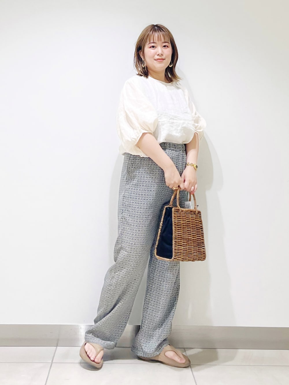 ブラック系のハンドバッグ、グリーン系のその他パンツ、ベージュ系のシャツ/ブラウスを着用したレディースの夏コーディネートの3枚目の写真