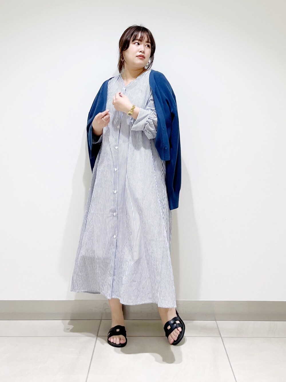 ブルー系のワンピース、ブルー系のニット/セーター、ブラック系のサンダルを着用したレディースの春コーディネートの4枚目の写真