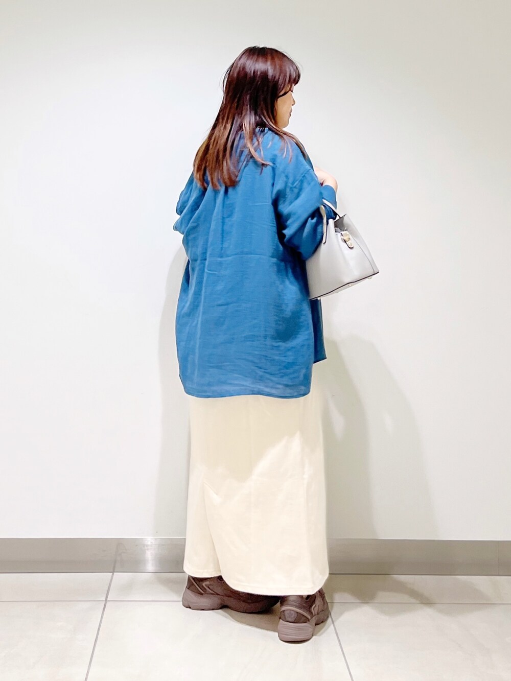 ブルー系のシャツ/ブラウス、ベージュ系のワンピース、グレー系のトートバッグを着用したレディースの夏コーディネートの7枚目の写真