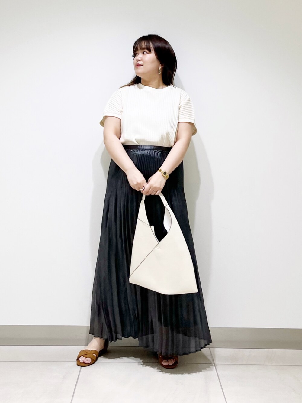 ホワイト系のニット/セーター、ホワイト系のトートバッグ、ブラック系のスカートを着用したレディースの夏コーディネートの3枚目の写真